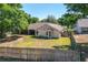 Expansive backyard enclosed by a wooden fence and surrounded by mature trees at 14421 Pine Cone Trl, Clermont, FL 34711