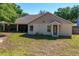 Spacious backyard featuring green grass and a view of the home's rear entrance at 14421 Pine Cone Trl, Clermont, FL 34711