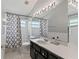 Well-lit bathroom features a large mirror, white countertop, and tiled shower at 14421 Pine Cone Trl, Clermont, FL 34711