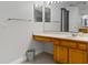 Well-lit bathroom featuring a wood vanity, countertop sink, and a large mirror at 14421 Pine Cone Trl, Clermont, FL 34711