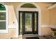 Elegant front door with decorative glass, side windows and hardware, providing a warm welcome at 14421 Pine Cone Trl, Clermont, FL 34711