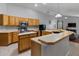 Spacious kitchen with light wood cabinets, stainless steel appliances, and a convenient island countertop for cooking at 14421 Pine Cone Trl, Clermont, FL 34711