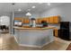 Functional kitchen with light wood cabinets, stainless appliances, an island counter, and a view into the living room at 14421 Pine Cone Trl, Clermont, FL 34711