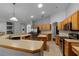 Spacious kitchen features stainless steel appliances, wood cabinetry, breakfast bar, and tile flooring at 14421 Pine Cone Trl, Clermont, FL 34711