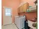 Functional laundry room with washer, dryer, storage cabinets, and access to outside at 14421 Pine Cone Trl, Clermont, FL 34711