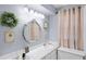Comfortable bathroom features a marble countertop, decorative mirror, and framed wall decor at 16 Pine Run, Haines City, FL 33844