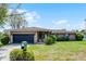 Charming single-story brick home featuring a well-maintained lawn, mature shrubs, and an attached garage at 16 Pine Run, Haines City, FL 33844