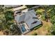 Aerial view showcases a spacious home with a screened pool and lush landscaping at 16730 Beauclaire Ct, Tavares, FL 32778
