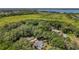 Aerial view of the home surrounded by mature trees, a screened pool, and a detached garage at 16730 Beauclaire Ct, Tavares, FL 32778