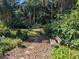 Bench seating in the serene backyard area with lush landscaping and a stone pathway at 16730 Beauclaire Ct, Tavares, FL 32778