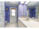 Bright bathroom with blue walls, white cabinets, and walkout access at 16730 Beauclaire Ct, Tavares, FL 32778