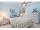 Light and airy bedroom featuring a blue and white color scheme, a ceiling fan, and white wicker furniture at 16730 Beauclaire Ct, Tavares, FL 32778