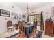 Elegant dining room with a traditional chandelier, dark table cover, and a large window overlooking the yard at 16730 Beauclaire Ct, Tavares, FL 32778