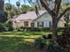 Well-maintained home exterior with manicured lawn and lush tropical landscaping at 16730 Beauclaire Ct, Tavares, FL 32778