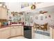 Bright kitchen with cream cabinets, a window over the sink, and a dining area with access to the outside at 16730 Beauclaire Ct, Tavares, FL 32778