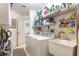 Well-organized laundry room with washer, dryer, sink, and ample shelving at 16730 Beauclaire Ct, Tavares, FL 32778
