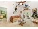 Cozy living room with a comfortable sofa, ceiling fan, and unique decor, next to door leading to a bedroom at 16730 Beauclaire Ct, Tavares, FL 32778