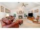 Spacious living room with a vaulted ceiling, fireplace, and comfortable leather furniture at 16730 Beauclaire Ct, Tavares, FL 32778