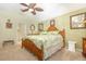 Cozy main bedroom with a tropical-themed bedspread, ceiling fan and an ensuite bathroom at 16730 Beauclaire Ct, Tavares, FL 32778