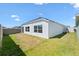 Backyard featuring white siding, dark roof, and manicured grass at 1674 Cadorette Dr, The Villages, FL 34762