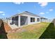 Backyard featuring screened patio, white fencing, and grass at 1674 Cadorette Dr, The Villages, FL 34762
