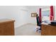 Neutral bedroom with closet, wood desk, red curtains, and an ergonomic office chair at 1674 Cadorette Dr, The Villages, FL 34762