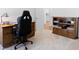 Neutral bedroom featuring desk, ergonomic office chair, bookcase, and view into hallway at 1674 Cadorette Dr, The Villages, FL 34762