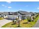 Beautiful single-story home with a large, attached three car garage and manicured lawn at 1674 Cadorette Dr, The Villages, FL 34762