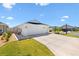 Bright white three car garage with large drive in front of a single story home at 1674 Cadorette Dr, The Villages, FL 34762
