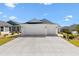 Wide three car garage on a single story home with a large concrete drive at 1674 Cadorette Dr, The Villages, FL 34762