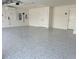 Clean garage with sealed concrete floors, white walls, storage, and a rollup door to keep your car dry at 1674 Cadorette Dr, The Villages, FL 34762