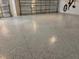 Spacious garage featuring a sealed concrete floor and a roll up garage door at 1674 Cadorette Dr, The Villages, FL 34762