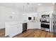 Modern kitchen features white cabinets, stainless steel appliances, and hardwood floors at 1674 Cadorette Dr, The Villages, FL 34762