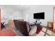 Bright living room featuring wood floors, a large TV, and a plush reclining chair at 1674 Cadorette Dr, The Villages, FL 34762