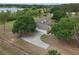 Aerial view showcasing the home, long driveway, and a well-manicured landscape at 17728 Palm View Cir, Mount Dora, FL 32757