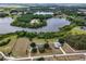 Aerial view of two homes on large lots surrounded by lakes and trees at 17728 Palm View Cir, Mount Dora, FL 32757