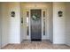 Elegant front door with sidelights, a decorative wreath, and nautical-themed sconces at 17728 Palm View Cir, Mount Dora, FL 32757
