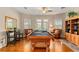 Spacious game room featuring a pool table, leather chairs, and ample natural light from surrounding windows at 17728 Palm View Cir, Mount Dora, FL 32757