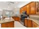 Well-lit kitchen with oak cabinets, granite counters, and stainless steel appliances at 17728 Palm View Cir, Mount Dora, FL 32757