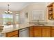 Well-lit kitchen with granite countertops, a stainless steel dishwasher, and oak cabinets at 17728 Palm View Cir, Mount Dora, FL 32757