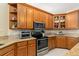 Kitchen featuring oak cabinets, granite counters and stainless steel appliances at 17728 Palm View Cir, Mount Dora, FL 32757