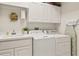 Well-lit laundry room with washer, dryer, sink, and ample cabinet space at 17728 Palm View Cir, Mount Dora, FL 32757