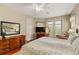 Comfortable main bedroom with a queen-sized bed, ensuite bath, hardwood floors and balcony access at 17728 Palm View Cir, Mount Dora, FL 32757