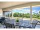 View of outdoor dining area on screened porch with view of green field at 17728 Palm View Cir, Mount Dora, FL 32757