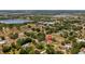 Aerial view of a property with a large lot, featuring a home with a pool, surrounded by lush trees and greenery at 17825 Whisperwind Dr, Clermont, FL 34715