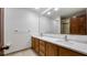 This bathroom includes a double vanity with a large mirror and a glass door shower at 17825 Whisperwind Dr, Clermont, FL 34715