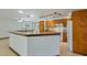 Open concept kitchen featuring a large island, granite countertops, and wood cabinets at 17825 Whisperwind Dr, Clermont, FL 34715