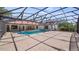 Expansive screened-in pool area with a swimming pool, hot tub, and ample patio for entertainment and relaxation at 17825 Whisperwind Dr, Clermont, FL 34715