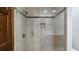 Bathroom shower with glass door, light tile and dark accents at 17825 Whisperwind Dr, Clermont, FL 34715