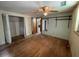 A bedroom features an open closet, hardwood floors, and two windows for natural lighting at 1920 Baxter Ave, Orlando, FL 32806